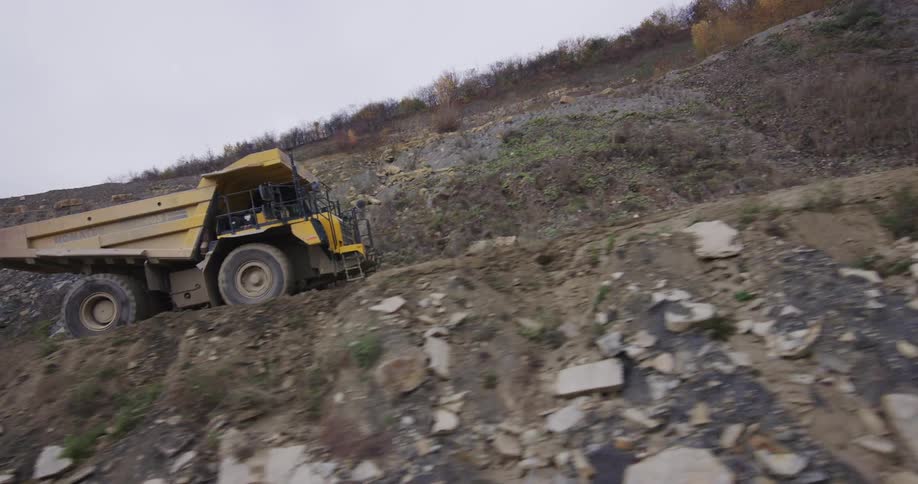 A dump truck drives through the rock quarry