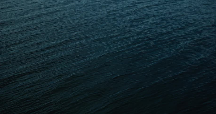 A vast expanse of deep blue ocean with gentle waves rippling across its surface