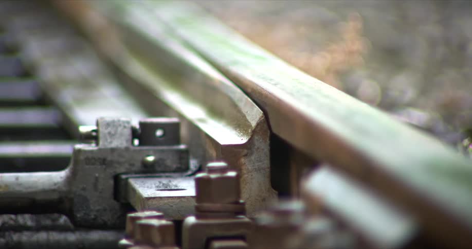 A railroad switch operating a change in tracks outdoors during daytime