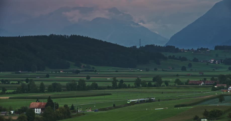 Serene valley at sunset with shades of green from the vast agricultural plains contrasting with the mountains