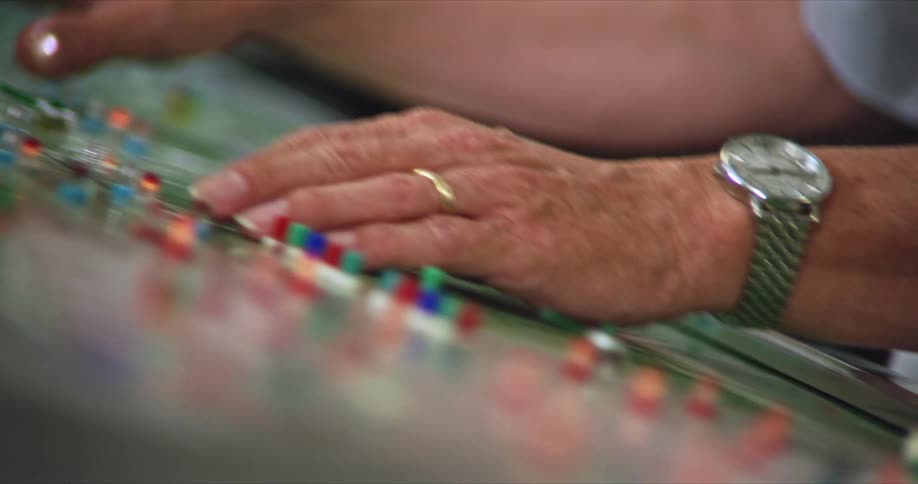 Pair of hands operating a control panel