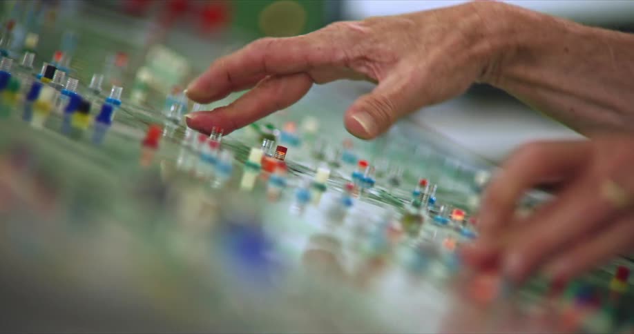 Elder person hands operating a machine by pressing buttons indoors