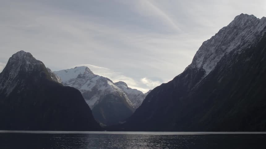 A view of a body of water under snow-capped mountains