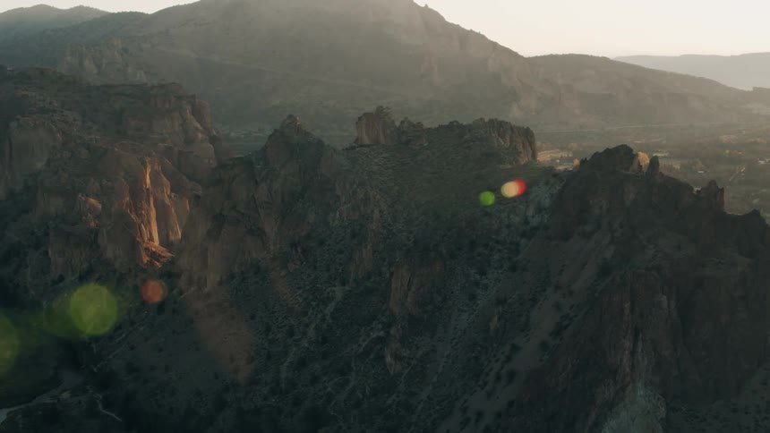 The sun shines through the fog on the mountains