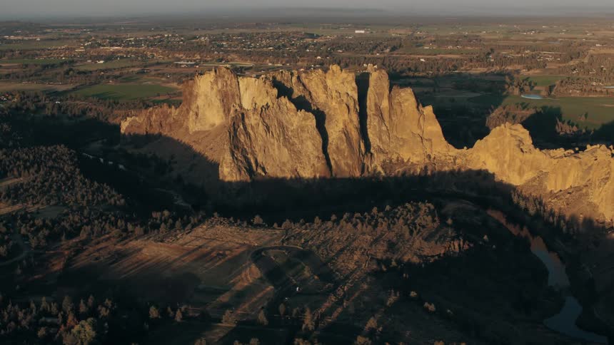 An aerial view of smith rock state park in oregon showcasing the rock formations bathed in the warm light of sunset