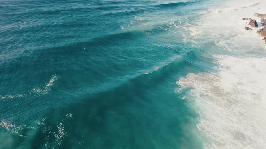 Aerial view of strong waves in a blue sea