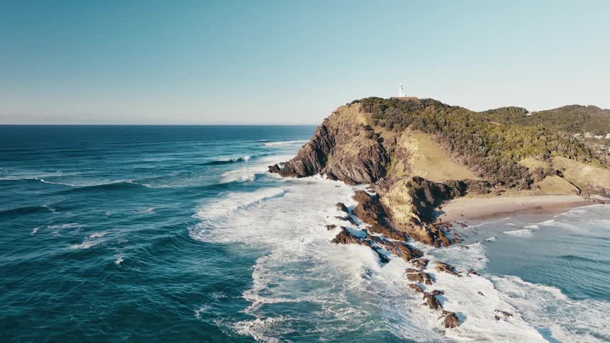 Aerial view of a beach with waves crashing on the rocky shore