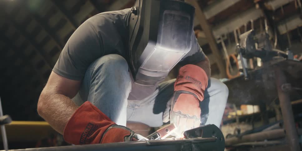 Man with protective helmet welding an object