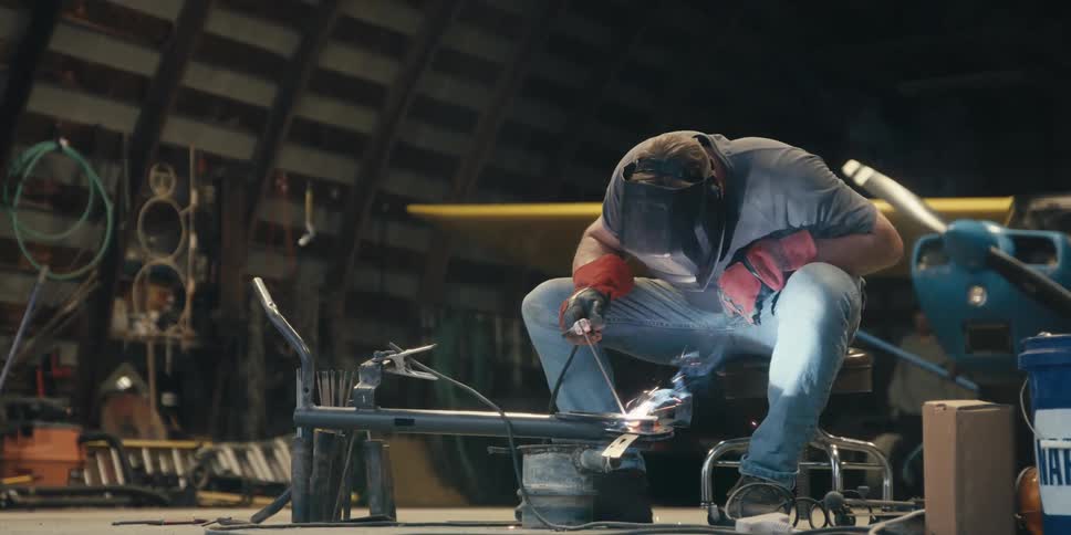 Man sitting welding a metal