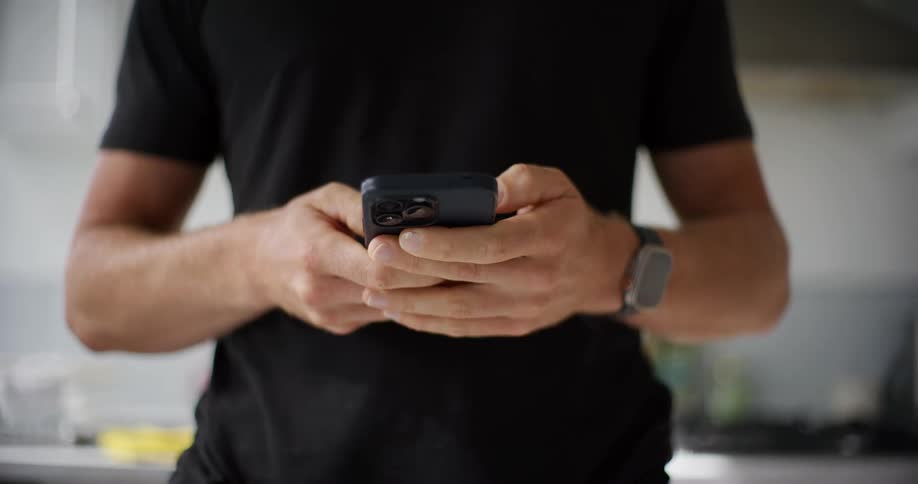 Close up of a persons hands typing on an iphone