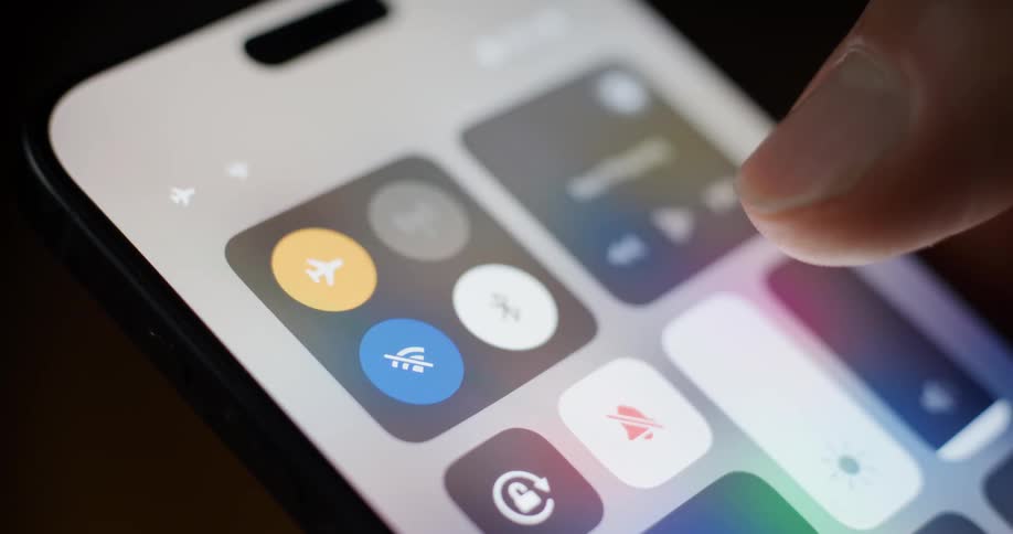 A smartphone screen with the control center open and a finger interacting with the screen