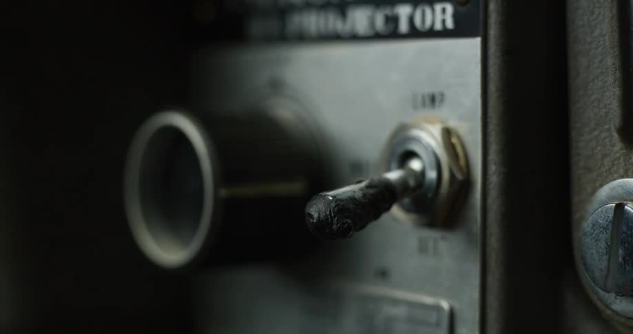 A finger presses a switch labeled lamp on a metal panel up and down