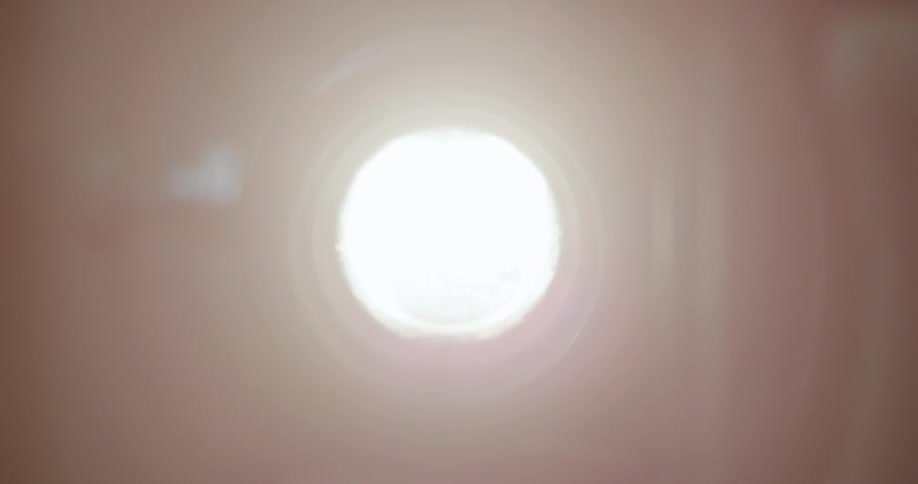 A dark circular object that then begins to glow brightly