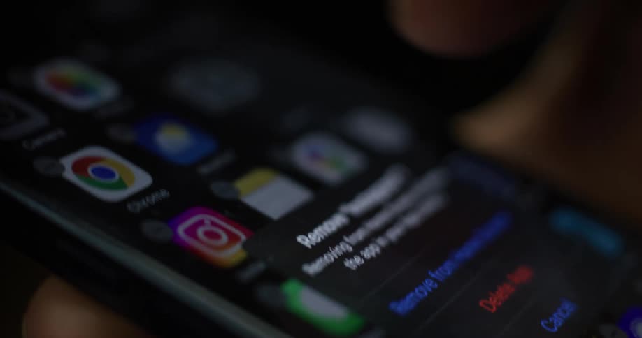 Close up of a person deleting apps from a smartphone