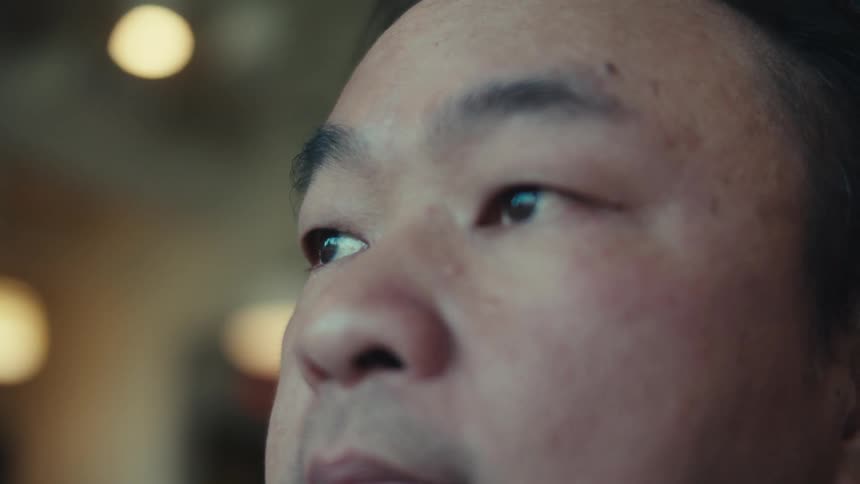 A man staring off into the distance inside a room