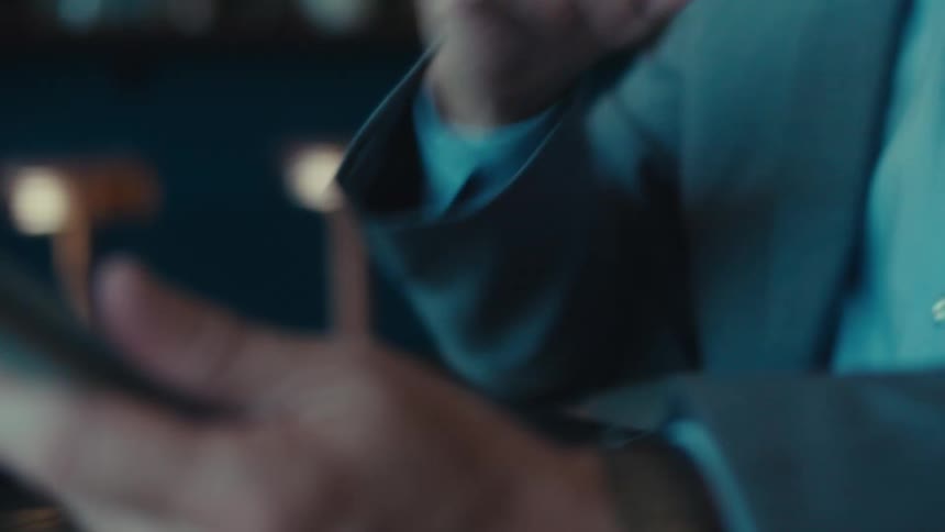 A man uses a stylus on his tablet as he sits in a building