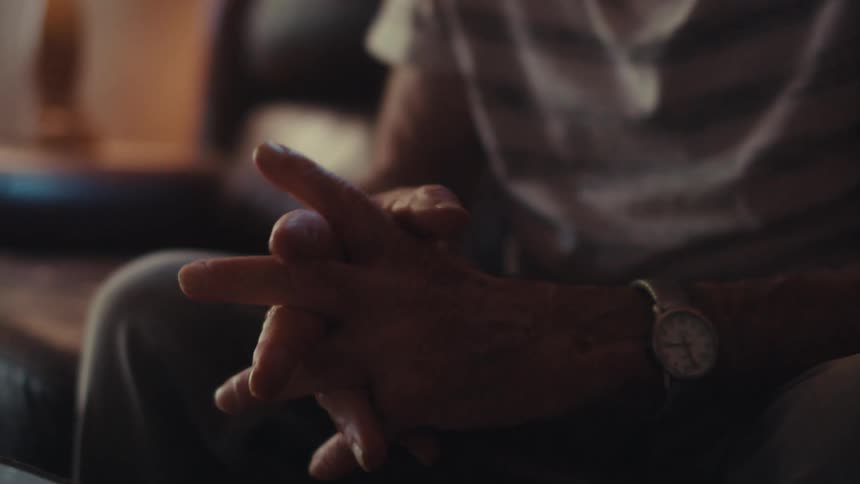 Elderly man sitting on the sofa in front of a tablet