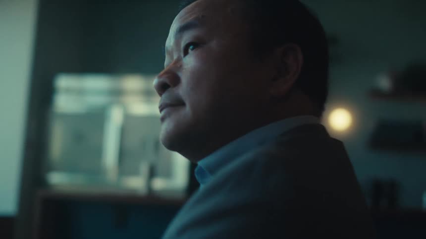 Man wearing a suit uses a tablet while sitting in an empty break room