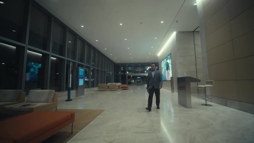 Man in a suit walking through a lobby at night