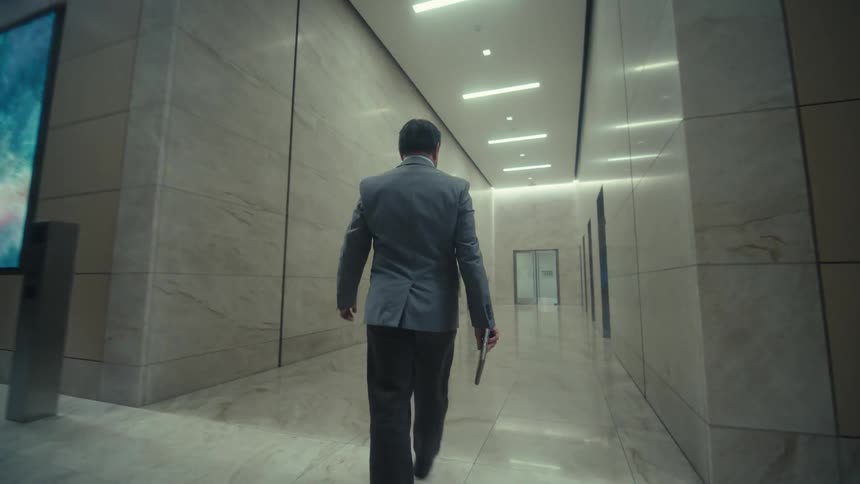 A back view of a man walking the corridor