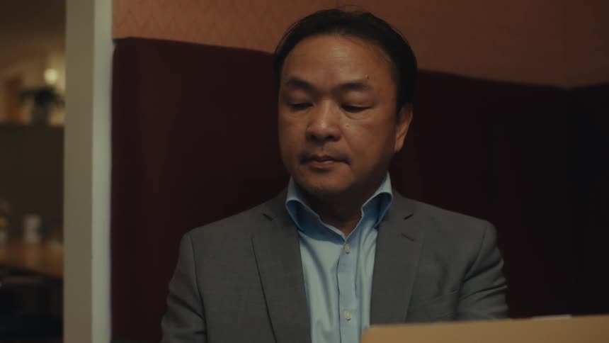 Businessman in a suit uses a laptop and smartphone