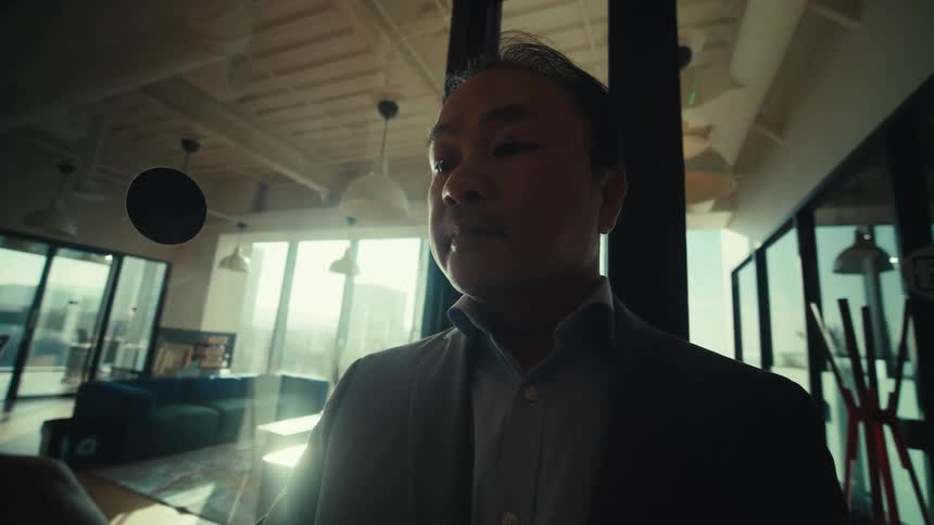 A clip of an asian man operating a smartphone indoor