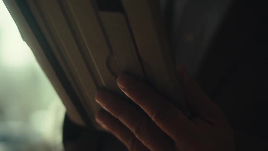 A businessman wearing a suit uses a tablet