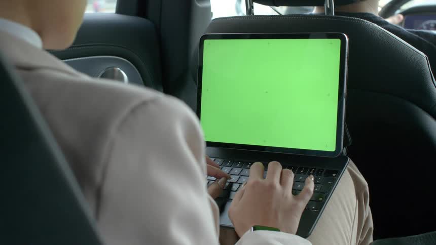 A footage of a person operating a tablet inside a car