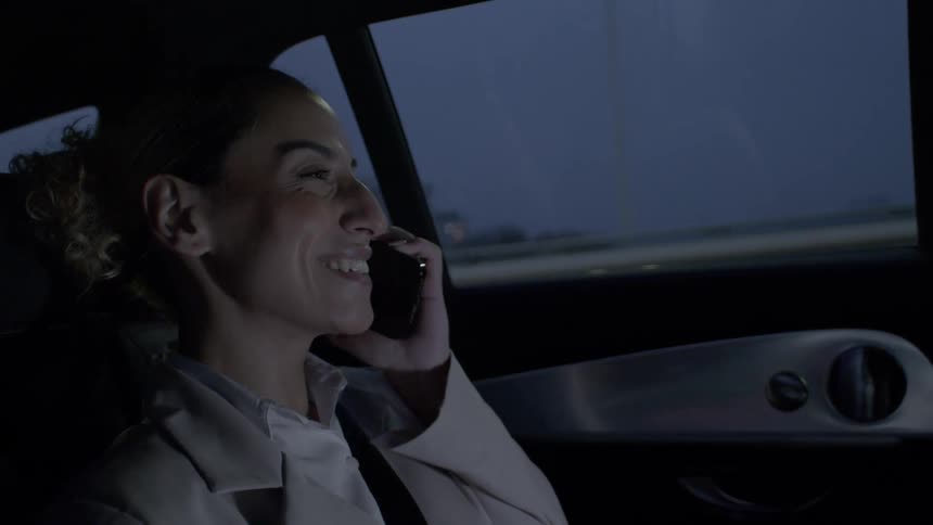 Woman talks on cell phone while riding in a car