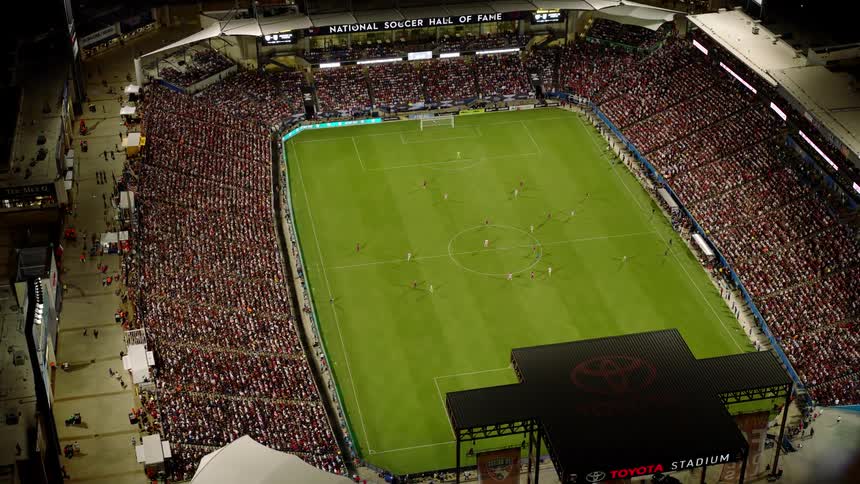 The crowd is watching a soccer game in the stadium