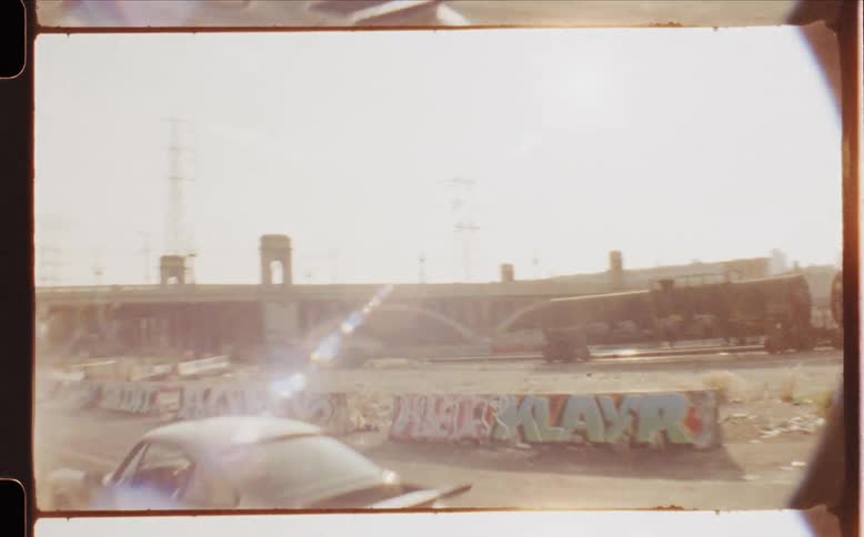 A car drives towards the bridge by the city