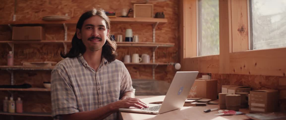 Portrait of a man using his laptop in his work shop