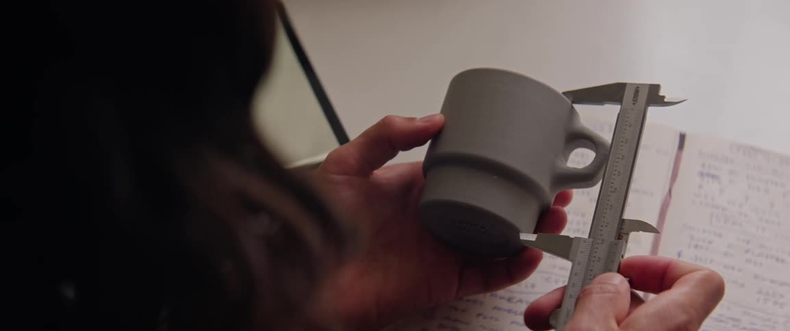 A person is measuring a cup with precision