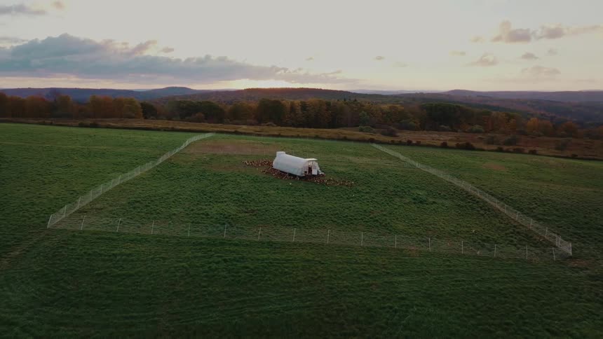 Aerial view of a greenhouse in a green field