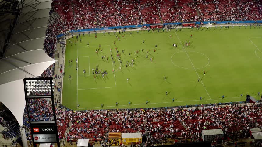 Soccer fans watch a soccer game at night at a stadium in texas