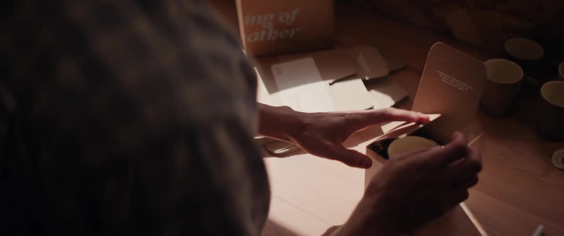 A man puts a sticker in a ceramics cup and seals the shipping box