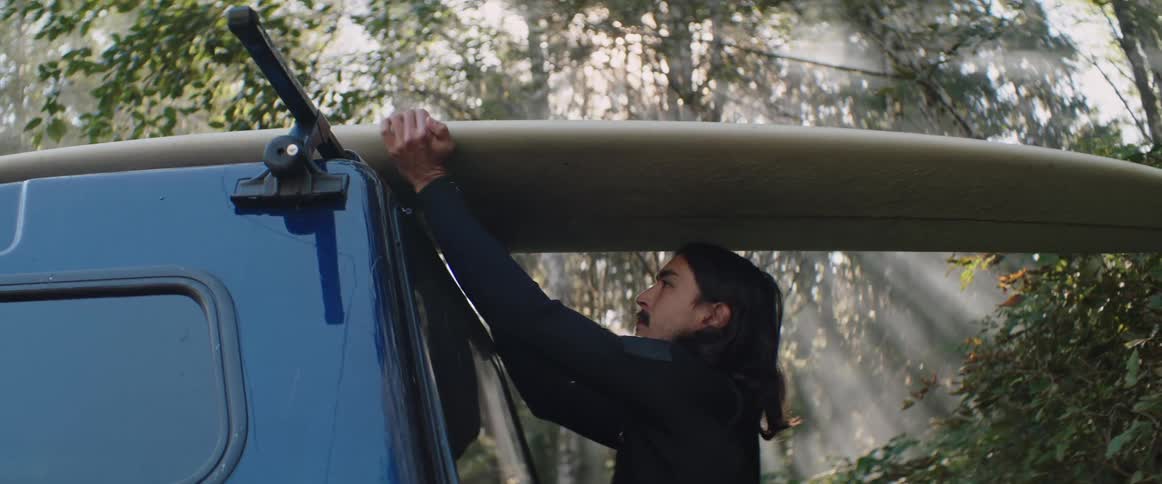 A clip of a person lifting a surfboard off their truck
