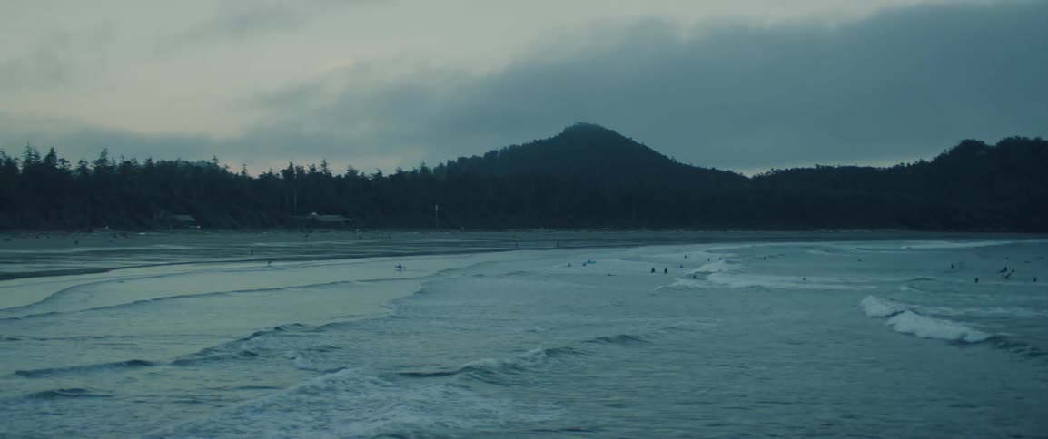 The ocean waves break towards shore on a cloudy day