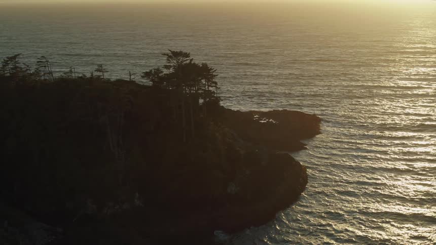 A rocky coastal outcrop seen from the air at sunset