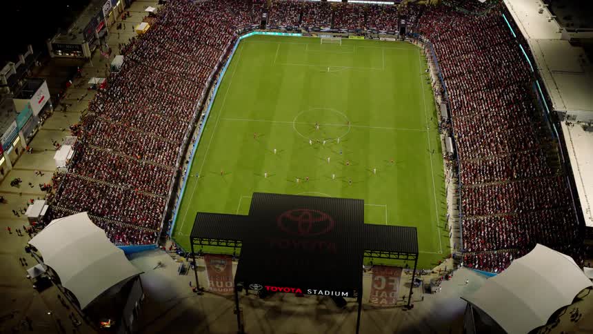 Aerial view of a football match taking place in a stadium and a crowd of fans