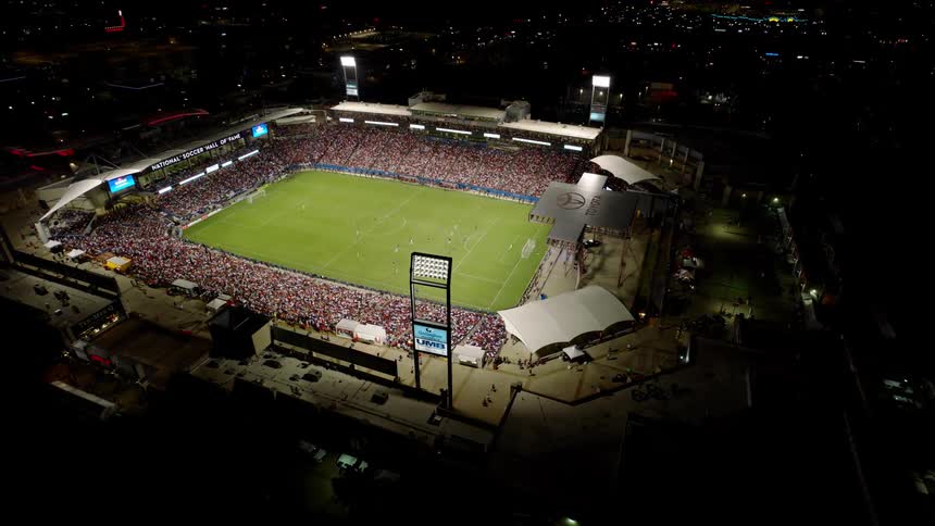 Aerial view of a crowd of people in an illuminated stadium at night