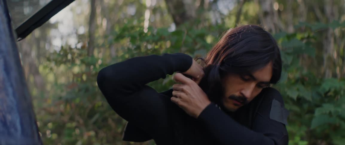 A man puts on a wet suit before surfing