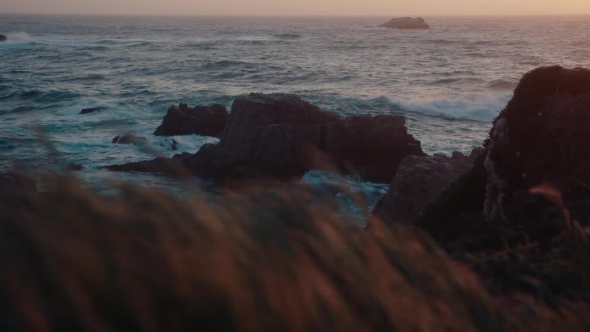 Rough waters crash on the rocks of the shore