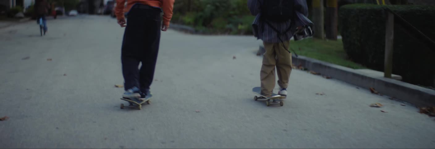 Teenagers are skateboarding down the road