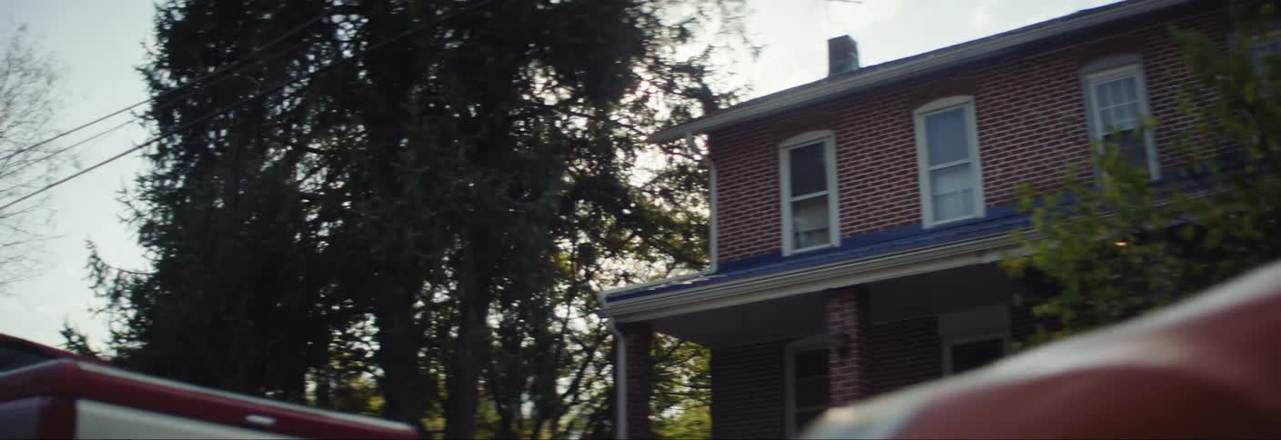 Houses are shown in a suburban neighborhood with parked cars lining the street