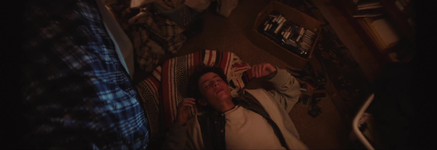 Young man lying on bedroom floor