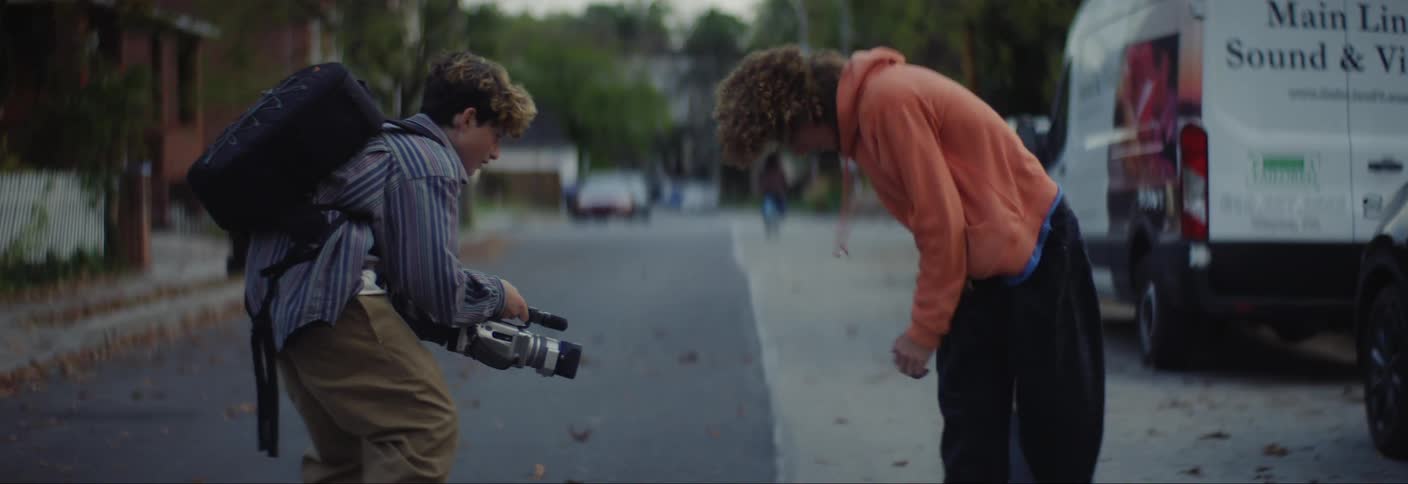 A teenager films his friend skateboarding