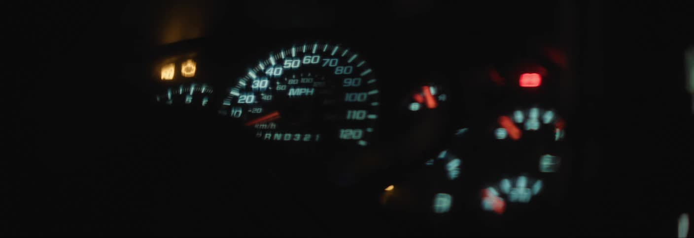 A cars interior gauge cluster is shown lit up as the needles all move to the farthest extent
