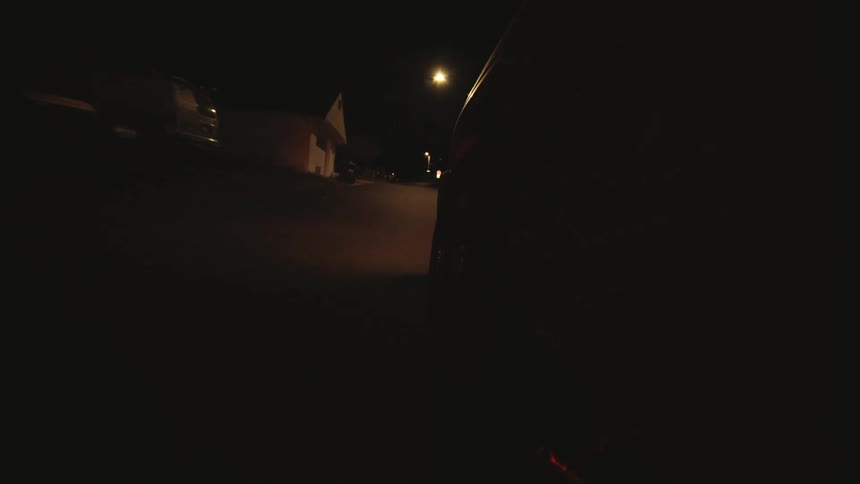 A car is driving on the road at night