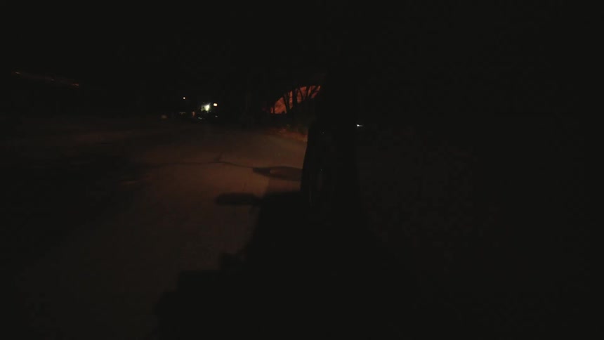 Point of view of a vehicle moving down a street at night